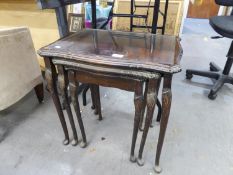 A NEST OF 3 MAHOGANY COFFEE TABLES WITH GLASS INSET TOPS, RAISED ON SLIM CABRIOLE LEGS