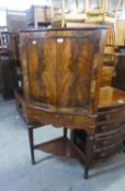 GEORGIAN STYLE FLAME FIGURED MAHOGANY CORNER COCKTAIL CABINET WITH SERPENTINE FRONT, TWO DOORS