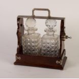 INTER-WAR YEARS MAHOGANY AND ELECTROPLATED TANTALUS with two large well-cut square glass decanters