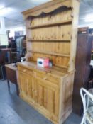 A PINE KITCHEN DRESSER WITH THREE TIER RAISED PLATE RACK