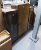 AN ART DECO CHINA DISPLAY CABINET WITH STEPPED TOP, HAVING CENTRAL PANEL DOOR, FLANKED BY TWO GLAZED