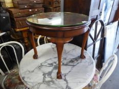 A MAHOGANY CIRCULAR COFFEE TABLE WITH MIRROR  GLASS TOP, ON FOUR CABRIOLE LEGS WITH CLAW AND BALL