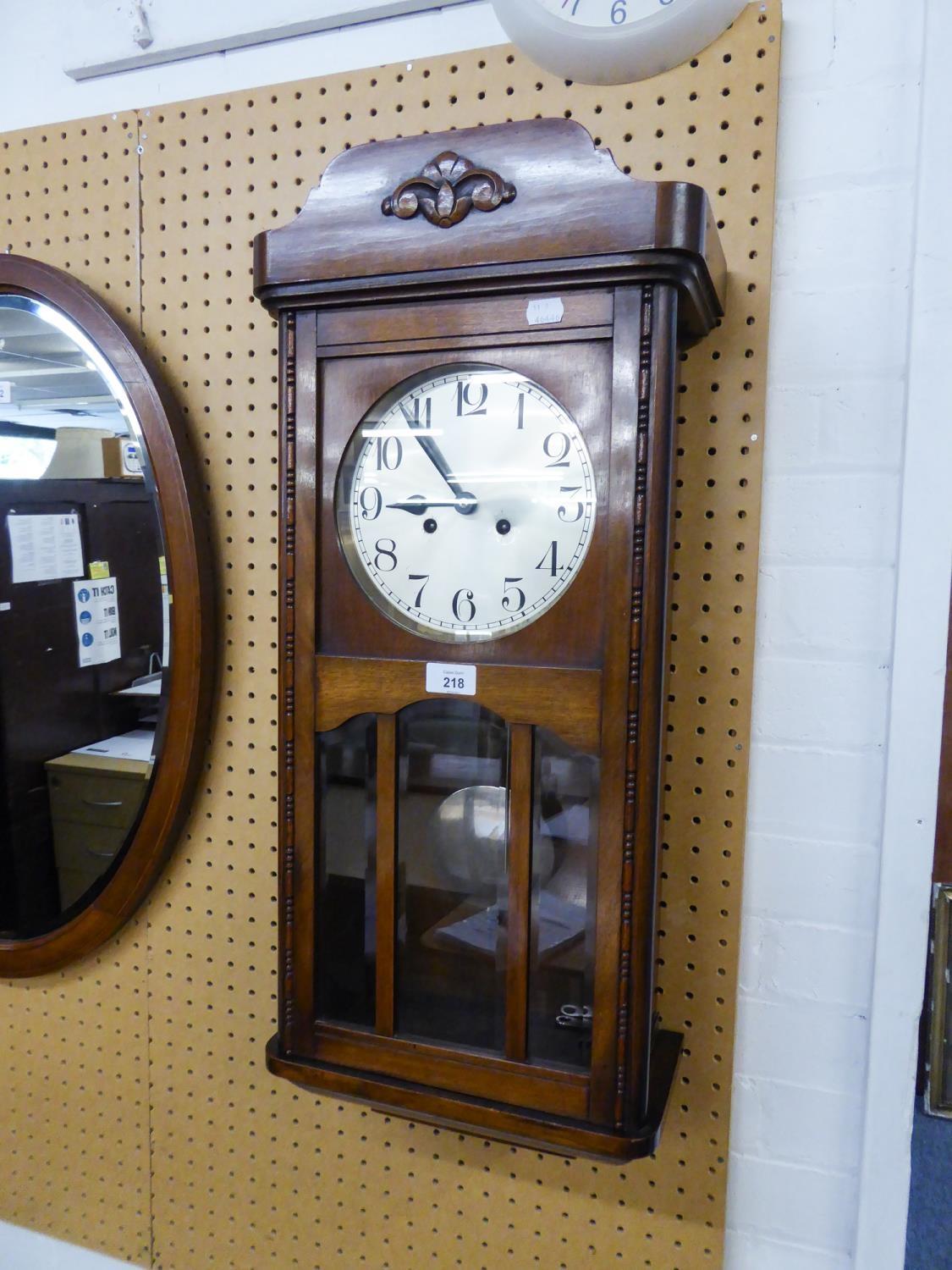 A WELLINGTON WALL CLOCK WITH CARVED OAK CASE, 8 DAYS MOVEMENT STRIKING THE ON THE HOUR AND HALF HOUR