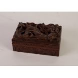 EARLY 20th CENTURY CARVED WOODEN BOX, the hinged lid in bold undercut relief with a mythical dragon,