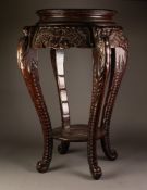 CHINESE CARVED WOOD URN TABLE with circular top and underplatform, on four figural carved cabriole