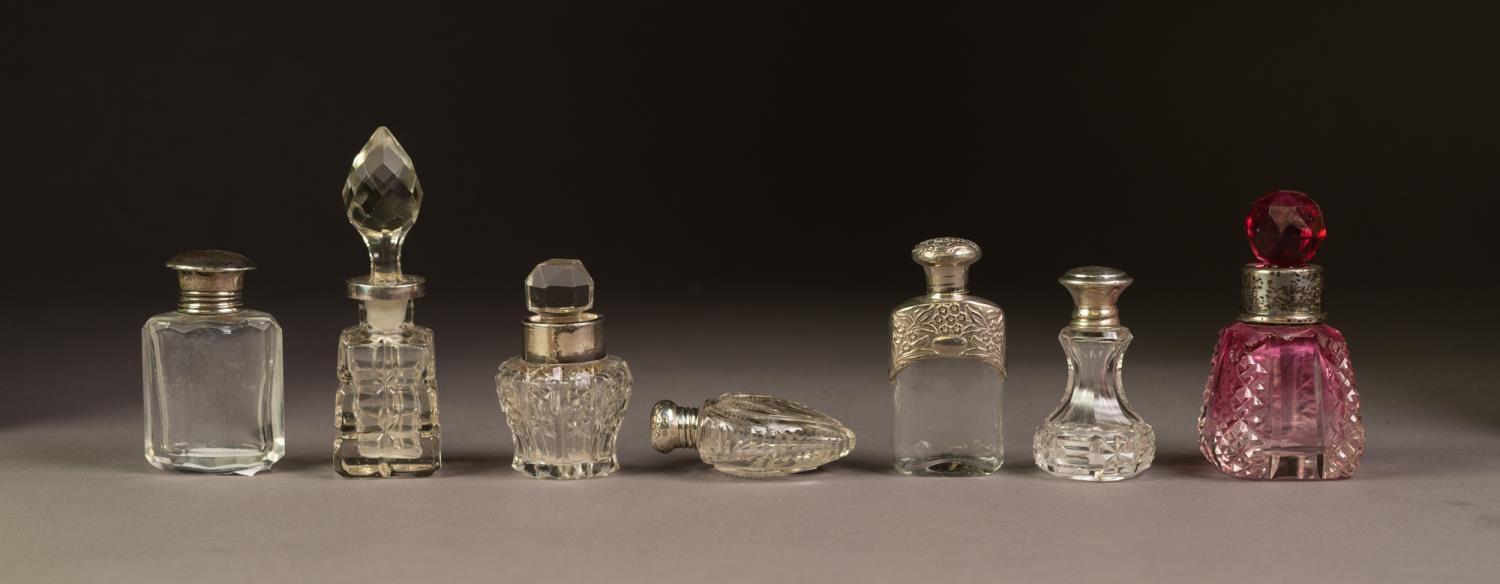 SEVEN VARIOUS GLASS PERFUME BOTTLES, four with hallmarked silver collars or tops, three with