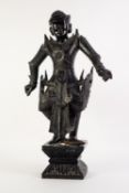 SIAMESE CARVED EBONY WARRIOR FIGURE in elaborate armour, 17in (43.1cm) high, standing on an integral