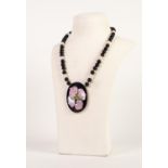 CHINESE SINGLE STRAND NECKLACE of black beads and eight white jade beads, with gold plated torpedo