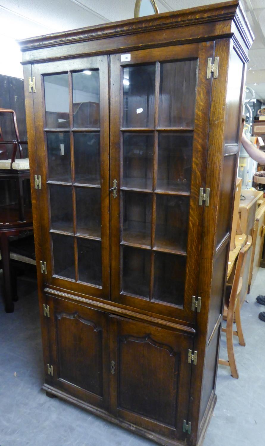 AN OAK BOOKCASE ENCLOSED BY TWO GLAZED PANE PANEL DOORS OVER TWO PANEL DOORS, 3? WIDE, 6? HIGH