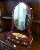 A LACQUERED OVAL SWING TOILET MIRROR, ON THREE DRAWER BASE