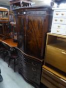 A FIGURED MAHOGANY COCKTAIL CABINET, WITH SERPENTINE FRONT, TWO DOORS OVER A SLIDE, DRAWER AND