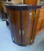 GEORGE III OAK AND MAHOGANY CROSS-BANDED BOW FRONTED HANGING CORNER CUPBOARD, ENCLOSED BY TWO DOORS