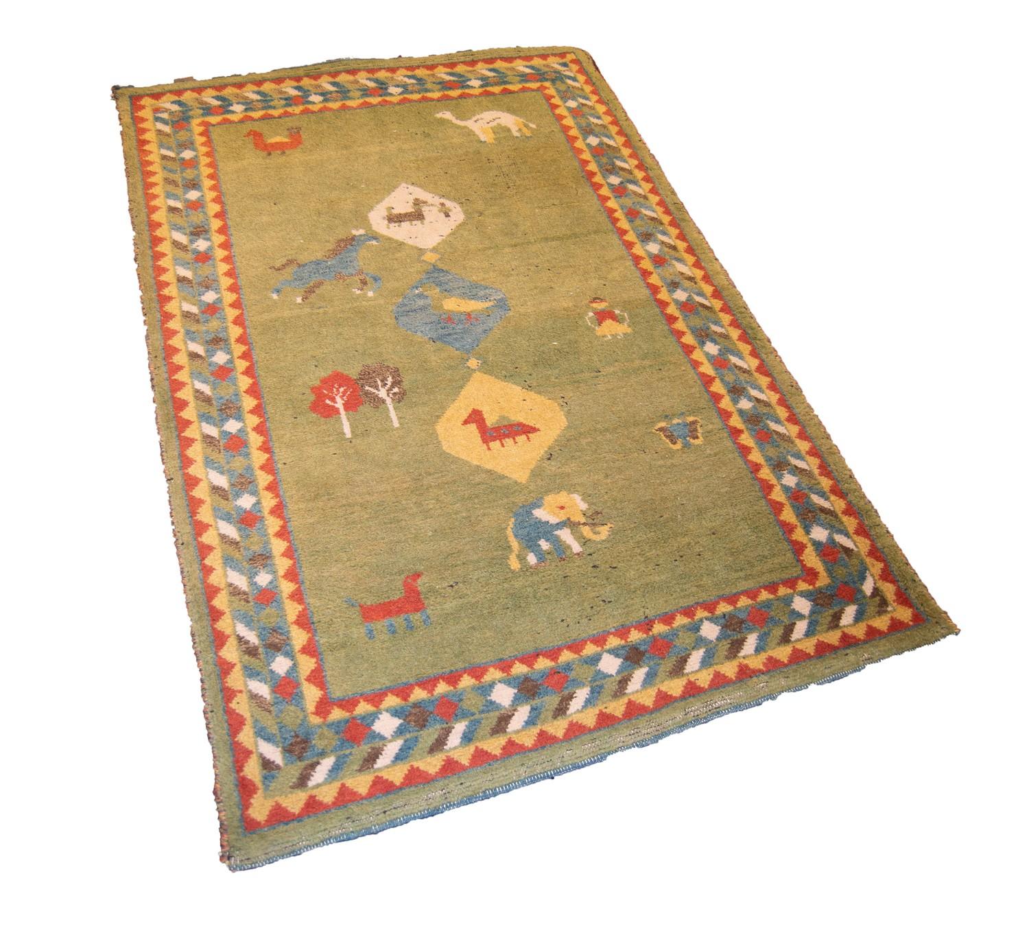 EASTERN CARPET with three small diamond shaped pole medallions featuring three animals, on a green