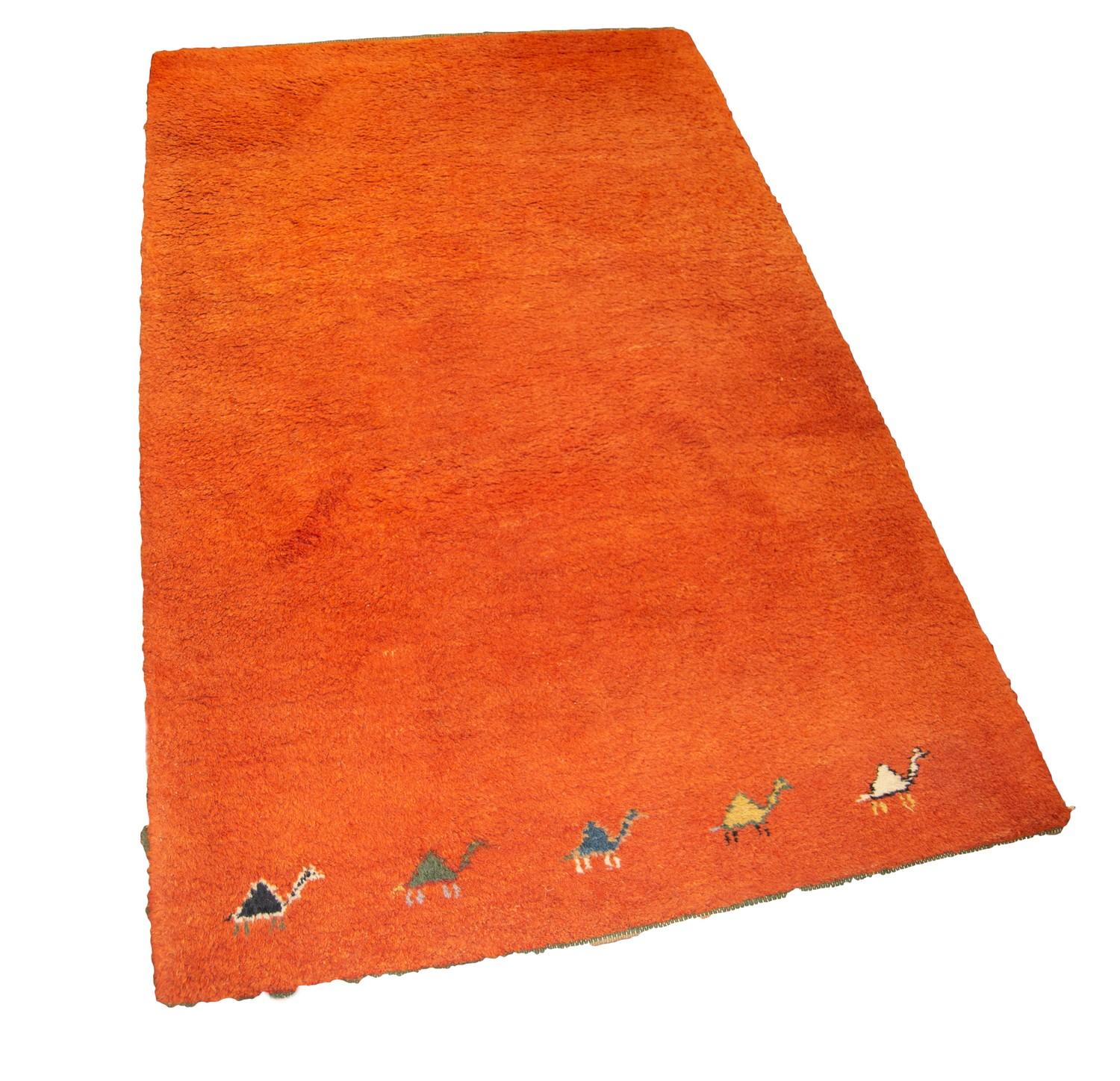 EASTERN MACHINE WOVEN PLAIN ORANGE SMALL CARPET with row of five camels to the bottom edge, 6ft x