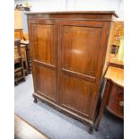 EARLY TWENTIETH CENTURY MAHOGANY HANGING ROBE the flat above a plain frieze and pair of twin