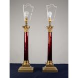 LARGE PAIR OF BRASS AND RED GLASS TABLE LAMPS, each of Corinthian column form with square, stepped