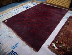 TURKOMAN BOKHARA CARPET, dark crimson with three rows of black stencilled large octagonal guls,