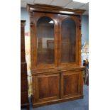 GOOD VICTORIAN BURR WALNUT BOOKCASE, the moulded cornice above a pair of cupboard doors, arched