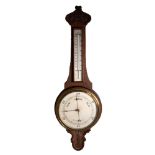 EARLY TWENTIETH CENTURY CARVED OAK BANJO ANEROID BAROMETER, with mercury thermometer to the trunk,