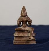 FAR EASTERN BRONZE MODEL OF KALI seated in a traditional pose, on high oblong base, 3 1/2in (8.