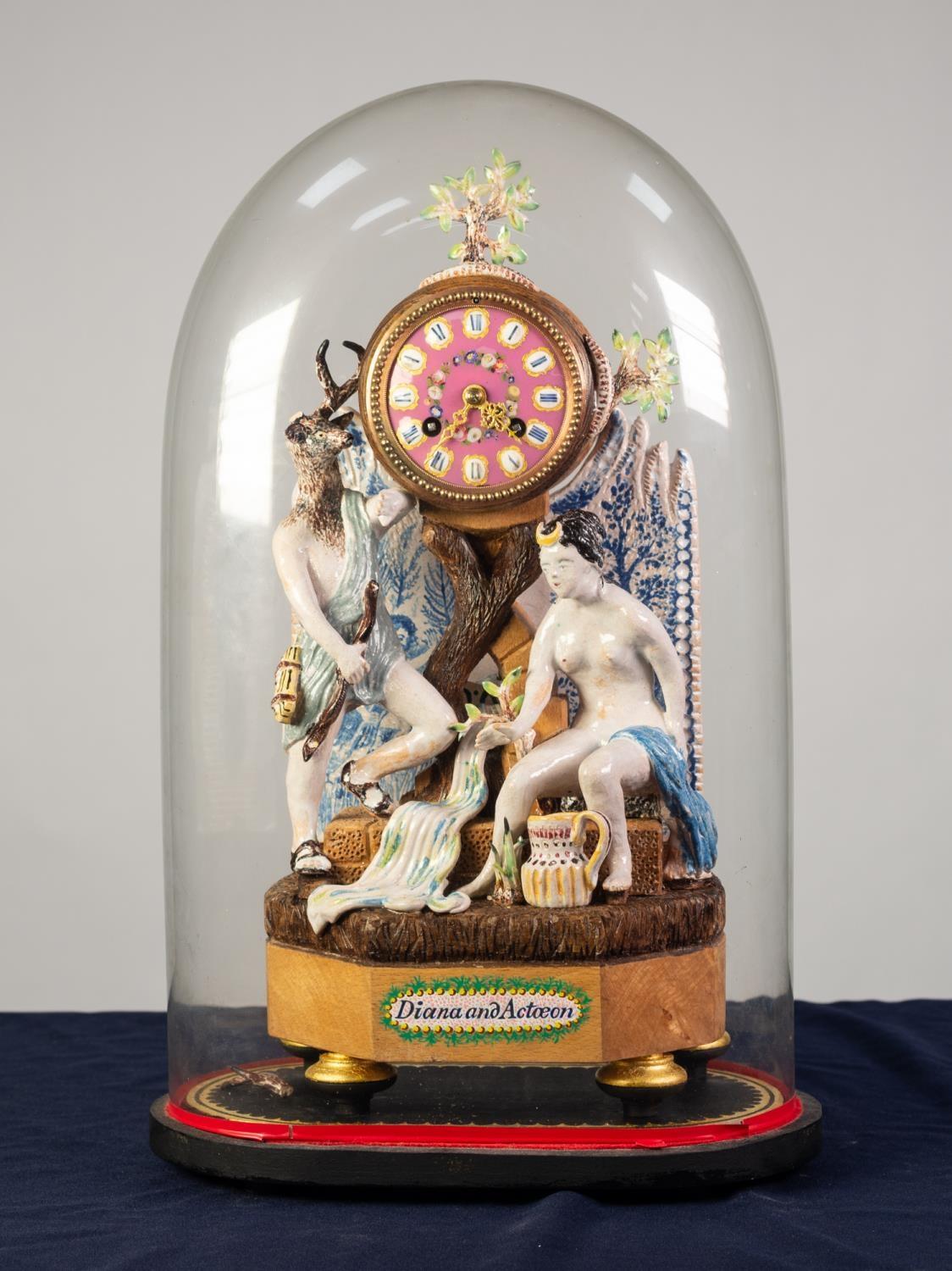 ?DIANA AND ACTOEON? COMPOSITE POTTERY AND WOOD FIGURAL MANTLE CLOCK, the 3? pink porcelain dial with