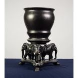 INDIAN WELL-CARVED EBONY CIRCULAR URN STAND supported by three elephants on a triform platform