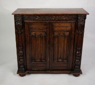 AGED OAK SIDE CABINET, the plain top above a cupboard enclosed with a pair of carved linen-old