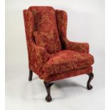 GEORGE III STYLE LARGE WINGED FIRESIDE ARMCHAIR, upholstered and coverd in embossed wine red and