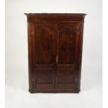 GEORGE III OAK FLAT FRONTED CORNER CUPBOARD, the moulded cornice above a pair of twin panelled