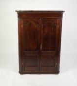 GEORGE III OAK FLAT FRONTED CORNER CUPBOARD, the moulded cornice above a pair of twin panelled