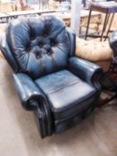 A LOUNGE CHAIR, BUTTON UPHOLSTERED IN BLUE HIDE WITH EXTENDING LEG REST