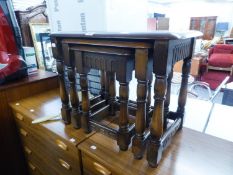 A NEST OF THREE JACOBEAN STYLE OAK OBLONG COFFEE TABLES, ON BALUSTER LEGS WITH PLAIN STRETCHER RAILS