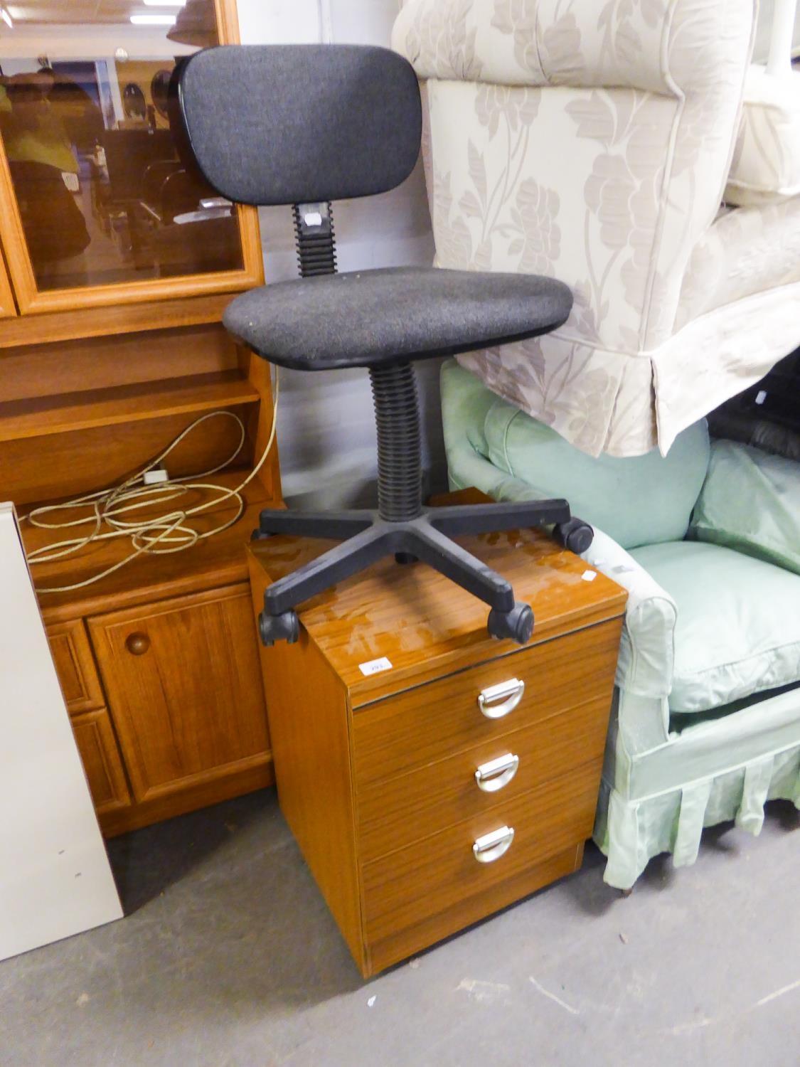 A TEAK DESK WITH METAL CANTILEVER SUPPORTS, CREAM ENAMELLED TOP AND THREE DRAWERS AND A REVOLVING