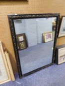 LARGE BEVELLED EDGE WALL MIRROR IN BLACK FRAME HAVING EMBOSSED GILT DECORATION