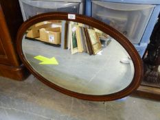 AN EARLY TWENTIETH CENTURY OVAL BEVEL EDGE WALL MIRROR, MAHOGANY WITH EBONY AND BOXWOOD ROPE PATTERN