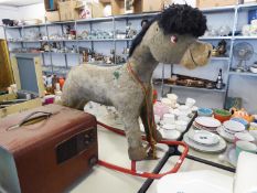 A FABRIC COVERED ROCKING HORSE, ON RED TUBUALR STEEL ROCKING BASE