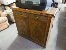 A SMALL MAHOGANY CARVED SIDEBOARD/CUPBOARD WITH TWO DRAWERS OVER TWO CUPBOARDS (SPLITS TO TOP)