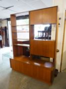 A MID-CENTURY G-PLAN LOUNGE UNIT AS AN OPEN BOOKCASE, SECRETAIRE AND CUPBOARD BASE AND AN EXTRA