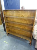 A LIGHT OAK THREE TIER OPEN BOOKCASE, HAVING ADJUSTABLE SHELVES ON STUMP CABRIOLE FEET