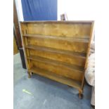 A LIGHT OAK THREE TIER OPEN BOOKCASE, HAVING ADJUSTABLE SHELVES ON STUMP CABRIOLE FEET