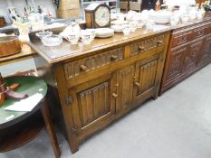 L. MARCUS LTD., LONDON, JACOBEAN STYLE OAK SIDEBOARD WITH ARCH CARVED FRIEZE DRAWERS OVER A LINEN-