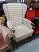 A WINGED FIRESIDE ARMCHAIR, COVERED IN CHECK PATTERN WOVEN FABRIC, ON CABRIOLE FRONT SUPPORTS