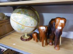 THREE GRADUATED WOODEN ELEPHANTS AND A SMALL GLOBE (4)