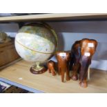 THREE GRADUATED WOODEN ELEPHANTS AND A SMALL GLOBE (4)