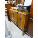 1930's CARVED OAK SIDEBOARD HAVING TWO CENTRAL DRAWERS, CENTRAL CUPBOARD DOORS AND TWO LARGE