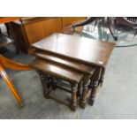 A NEST OF THREE JACOBEAN STYLE OAK OBLONG COFFEE TABLES, ON BALUSTER LEGS WITH PLAIN STRETCHER RAILS