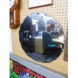 A CIRCULAR FRAMELESS WALL MIRROR WITH FANCY BEVELLED EDGE