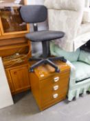 A TEAK DESK WITH METAL CANTILEVER SUPPORTS, CREAM ENAMELLED TOP AND THREE DRAWERS AND A REVOLVING