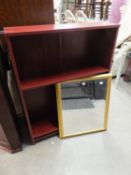 A MAHOGANY EFFECT THREE TIER OPEN BOOKCASE AND AN OBLONG BEVELLED EDGE WALL MIRROR, IN GILT FRAME