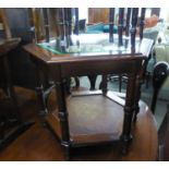 A MAHOGANY OCTAGONAL COFFEE TABLE WITH BEVELLED GLASS TOP AND CANE UNDERPLATFORM